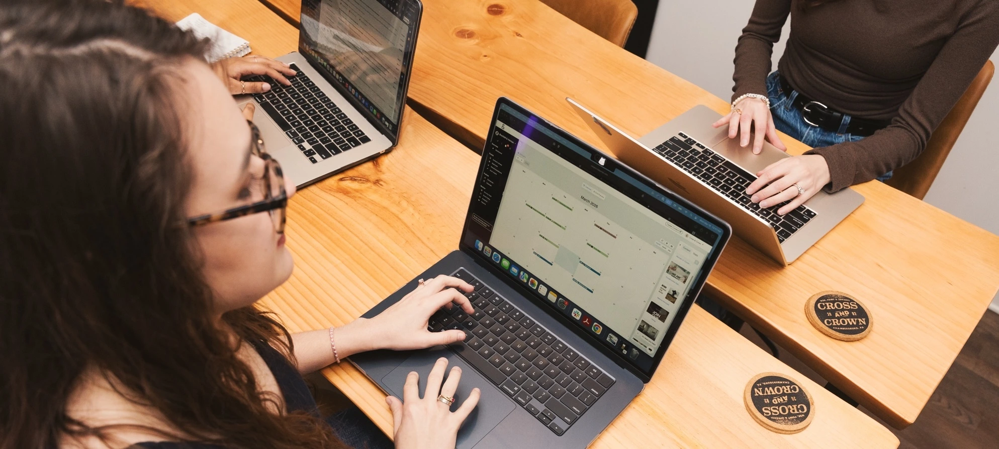 Cross & Crown employee looking and typing on laptop