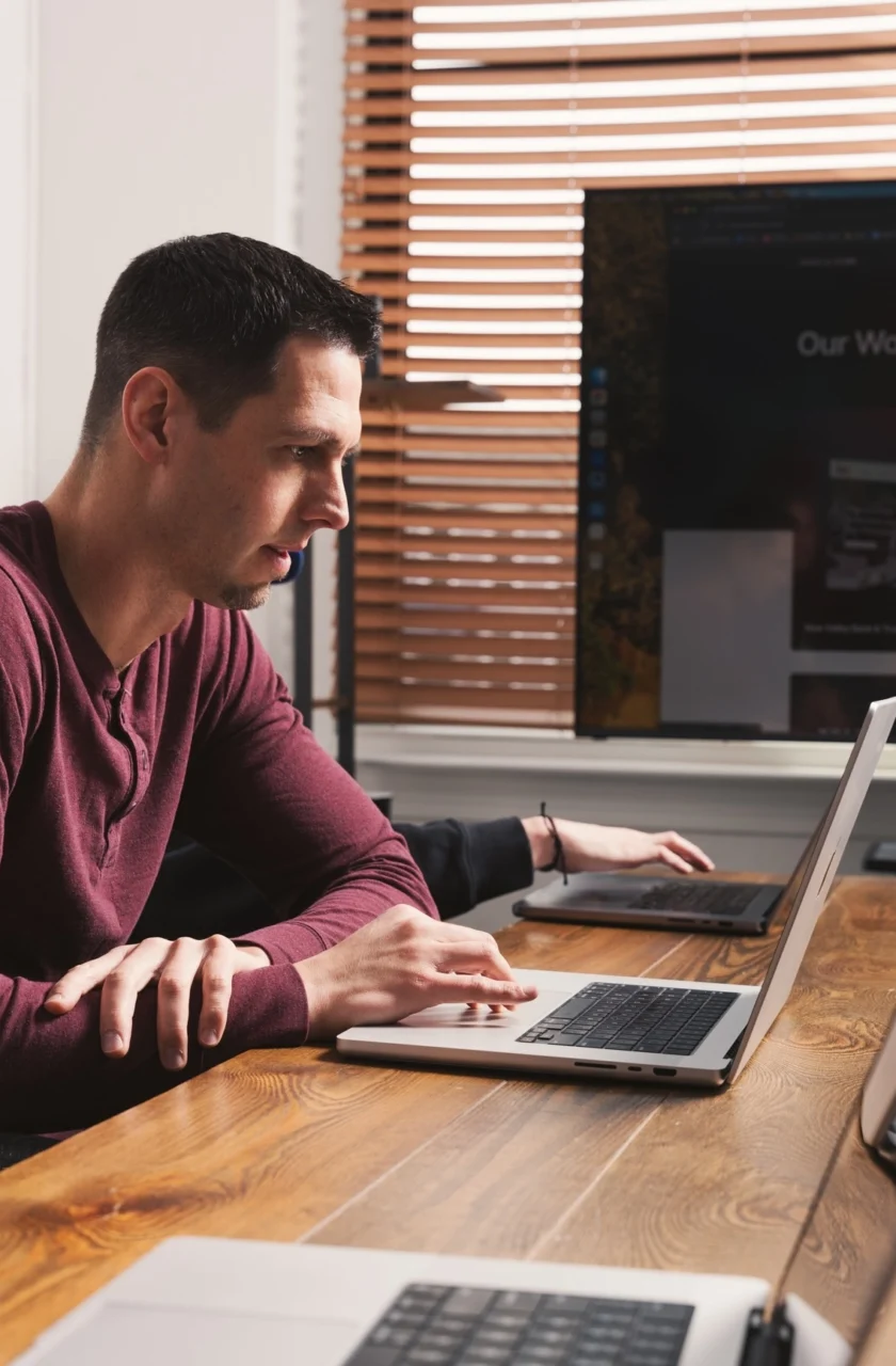 Cross & Crown employee sitting at table looking at laptop
