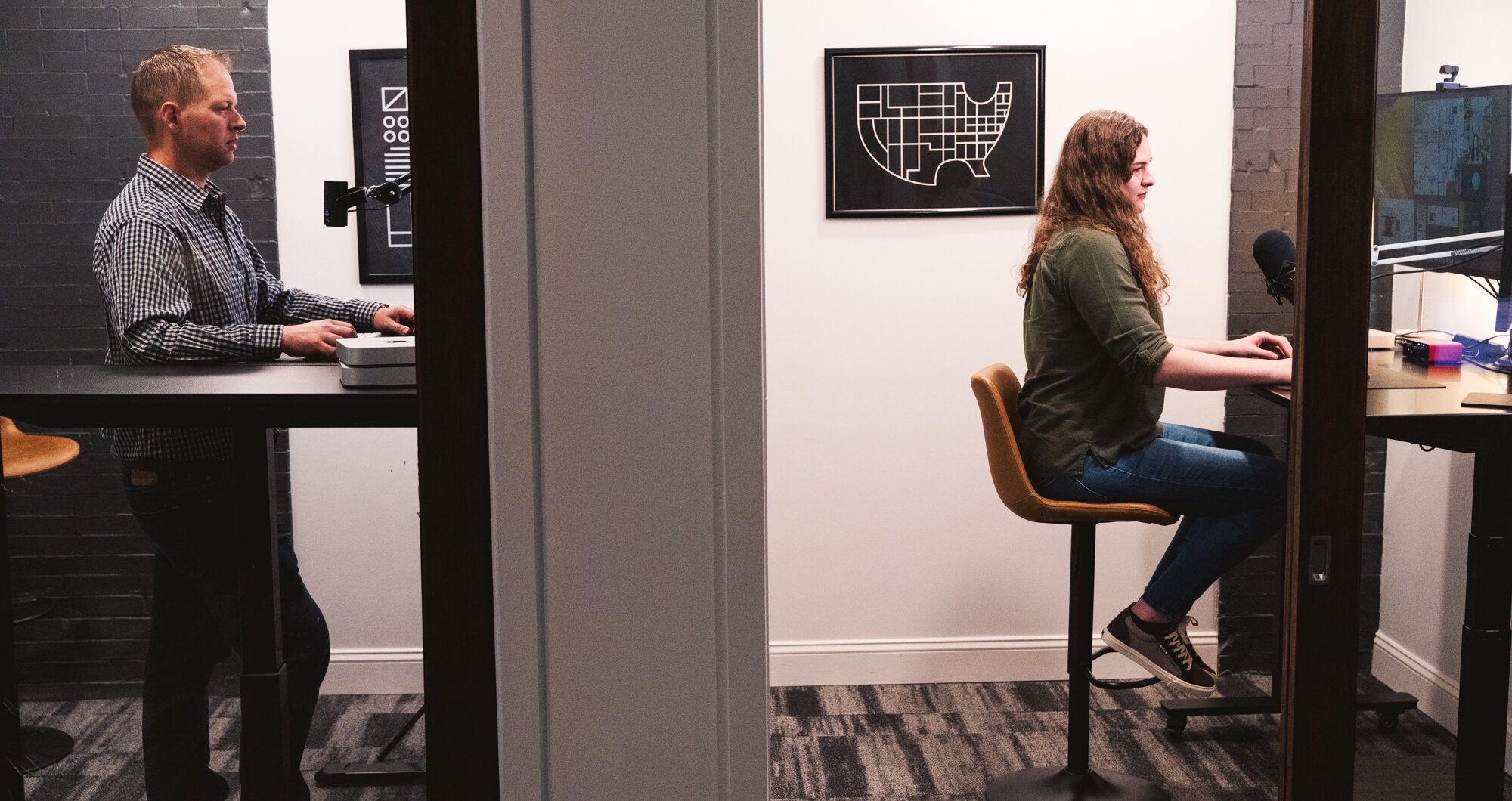 Two Cross & Crown team members in pods at virtual production stations.