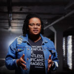 Spoken word by a female artist performed in a warehouse.