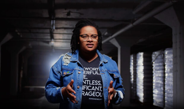 Spoken word by a female artist performed in a warehouse.