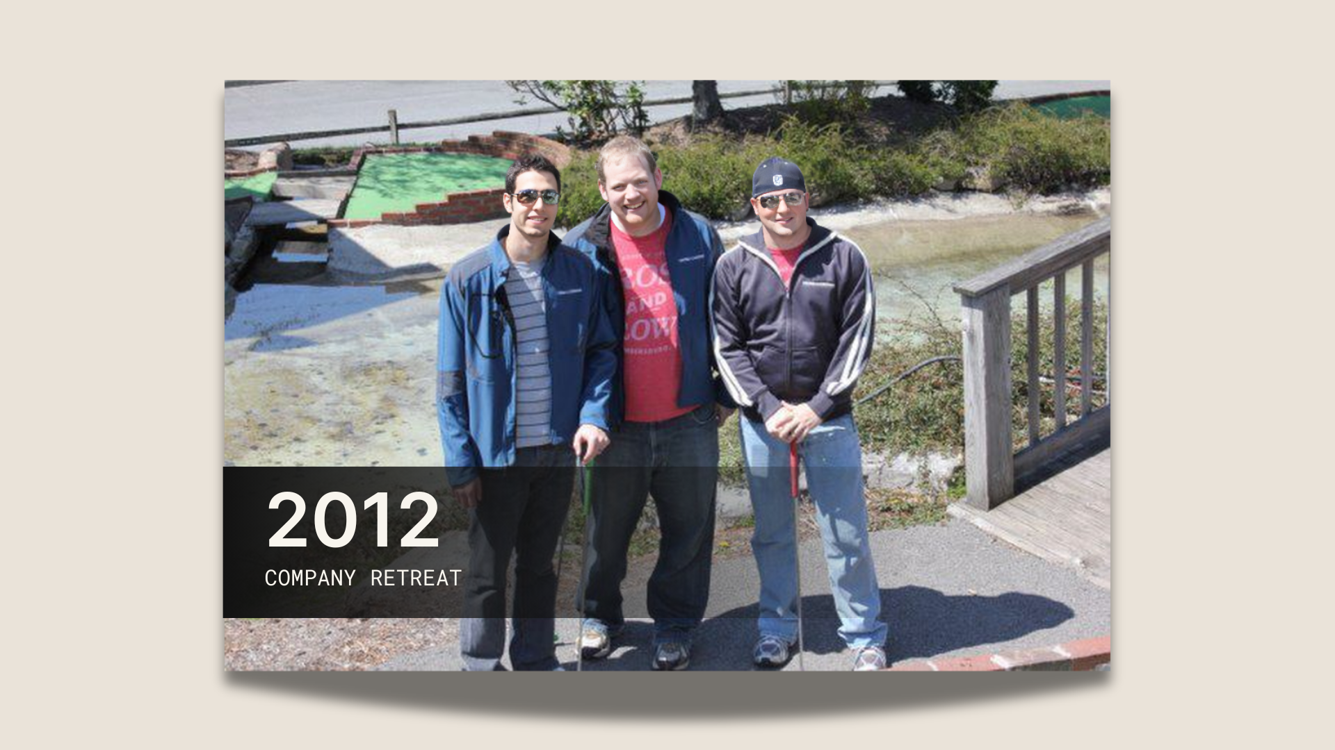 men standing next to each other in front of a pond