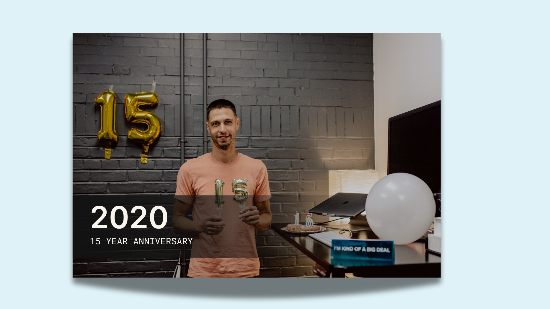 A person holding up a balloon with the number 15 on it