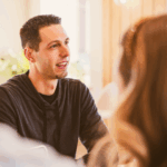 a person talking to a group of people at a meeting