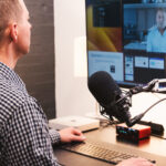 Man on a video call in front of a monitor.