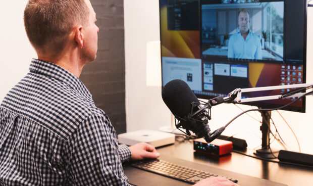 Man on a video call in front of a monitor.