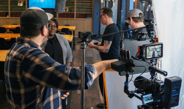 A person standing in front of a video camera in a room