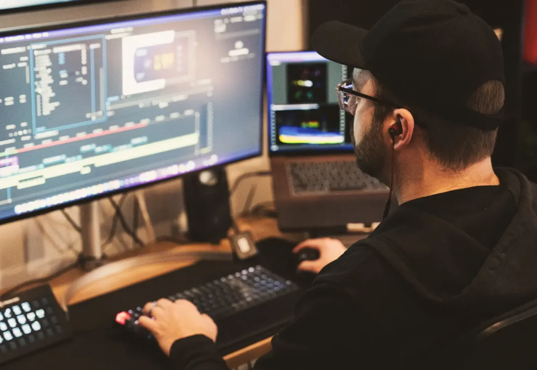 A man looking at a computer screen, creating video