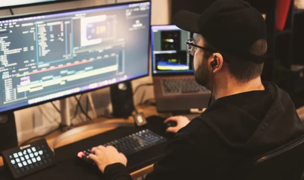 A man looking at a computer screen, creating video