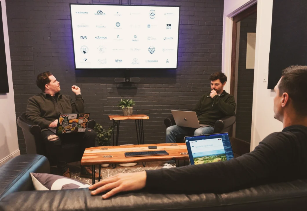 A person looks at a computer screen displaying a website with images of people hiking and text about graphics and trails.