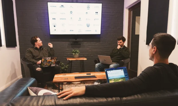 A person looks at a computer screen displaying a website with images of people hiking and text about graphics and trails.